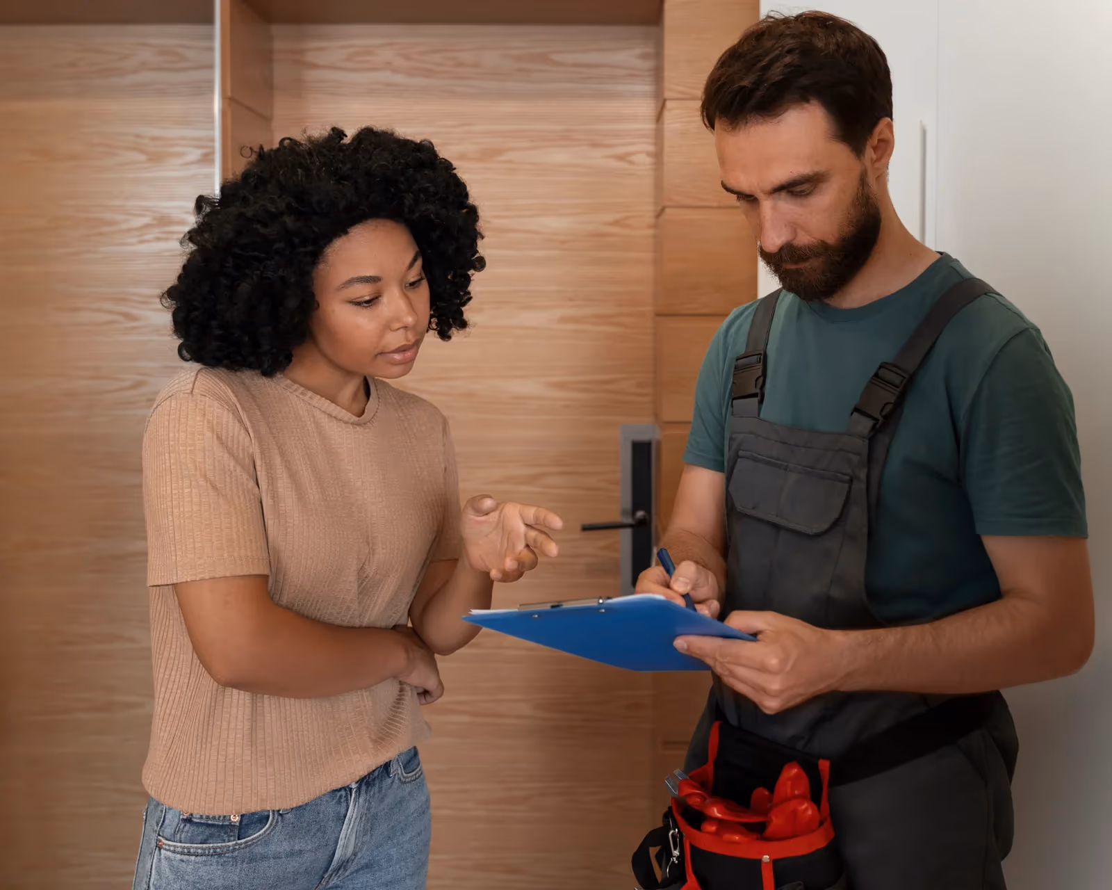 Ein Sanitärhandwerker bespricht die anstehenden Arbeiten mit einer Kundin
